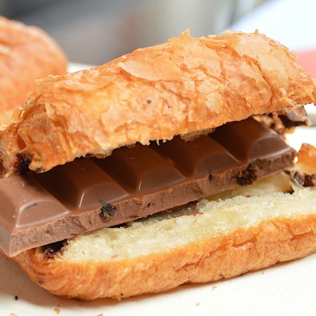 A croissant, halved and filled with a chocolate bar.