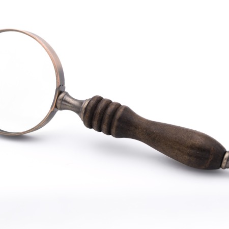 A large old-fashion handheld magnifying glass, propped onto its side.
