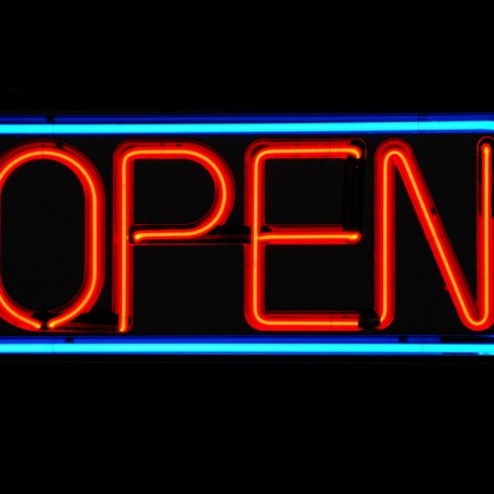 A red neon open sign, bordered by a blue neon line, set against a black background.